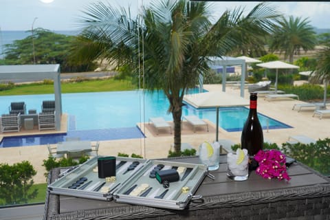 Enjoy cocktails and a game of backgammon on your private balcony overlooking the sparkling pool and tropical gardens, with stunning ocean views beyond.