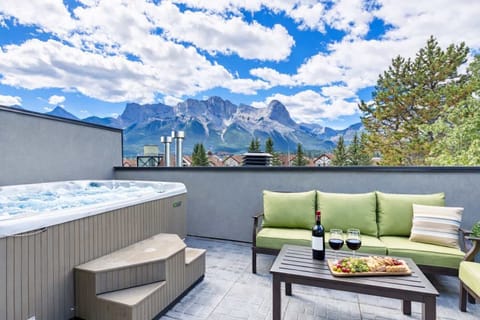 Top floor south-facing deck with 4 person hot tub, comfy outdoor seating and gas BBQ