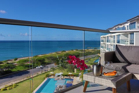 Stunning panoramic sea views from your private balcony, complete with cozy seating, chilled champagne, and fresh flowers—perfect for watching waves roll in and savoring tranquil coastal moments.