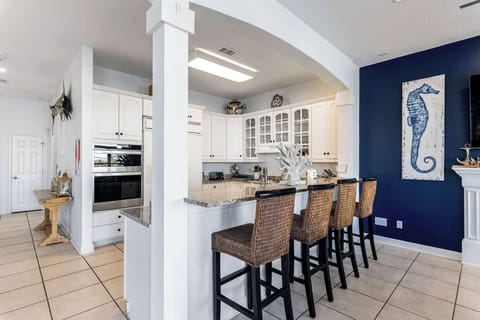 Open kitchen & bar seating w/ bright finishes and an easy flow to dining.