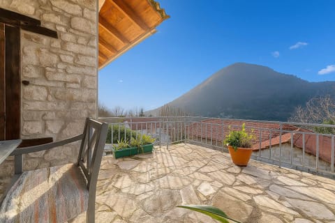 Panoramic Terrace View – Expansive stone terrace with mountain vistas and cozy seating, ideal for morning coffee or sunset relaxation.