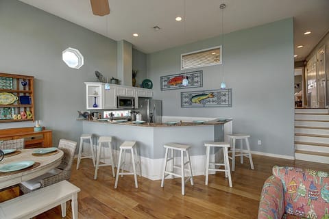 Kitchen - Step into this stylish coastal retreat featuring an open-concept kitchen and living area