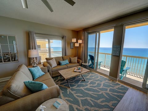 Sink into plush seating while endless ocean views fill your horizon through floor-to-ceiling windows in this bright, coastal-inspired living room.