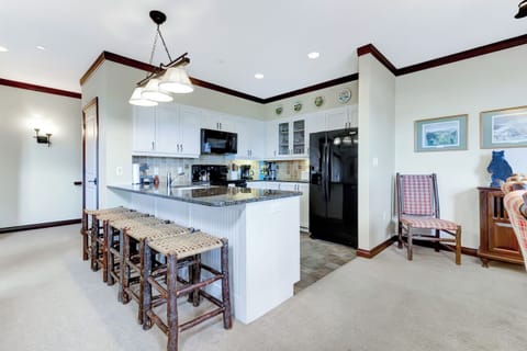 - Modern kitchen with granite counters and rustic bar stools   - Fully equipped with sleek black appliances and ample space   - Perfect setup for family breakfasts before hitting the slopes
