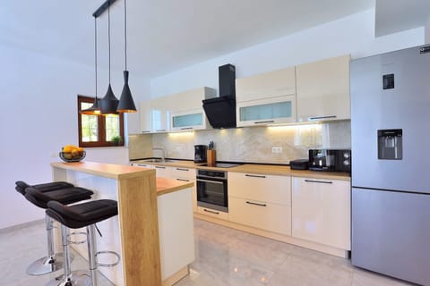 A Fully equipped kitchen with dining area and direct exit to the pool and outdoor dining area