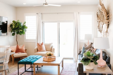 Light-filled living room with stylish seating, a large TV, and direct patio access—an inviting space to relax, watch movies, or gather after a day out.