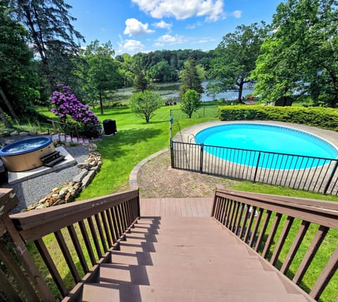 A beautiful view of the heated pool, hot tub, and lake on a gorgeous day!