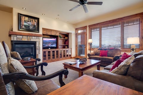 Unwind in your elegant living room with stone fireplace, flat-screen TV, and plush seating facing mountain views.