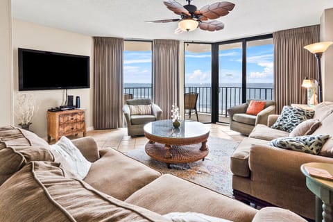 Ocean-view living room with sectional seating and balcony doors at Summit 7A, a 4-bedroom Windy Hill rental