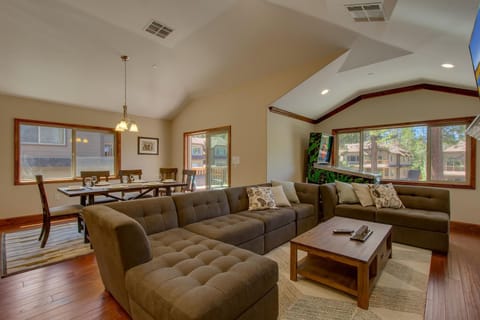 - Large sectional sofa in open living room  
- Dining table with seating for the group  
- Fun arcade game for family entertainment