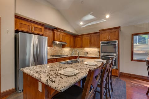 - Fully equipped chef's kitchen design  
- Double ovens and stainless steel fridge  
- Granite island with seating for guests