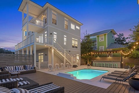 Evening pool view w/ soft lighting and relaxed coastal ambiance.