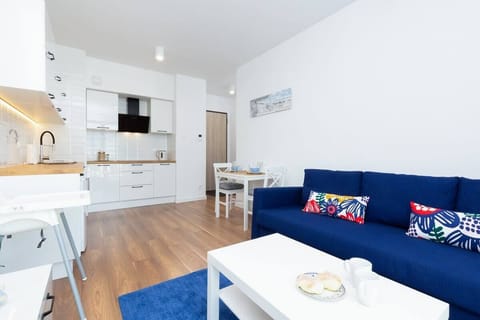 A living space with a blue sofa, coffee table, and a window providing natural light.