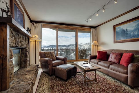 Unwind in your cozy mountain retreat with leather seating, a stone fireplace, and stunning balcony views.