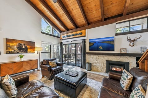 Unwind in this stunning mountain retreat with soaring wood-beam ceilings, cozy fireplace, and plush leather seating—your perfect alpine escape awaits.