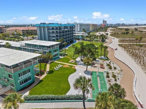 Aerial view of our resort grounds, featuring shuffleboard courts, a picnic area with grills and a fire pit, and direct access to the Treasure Island Boardwalk and beach.