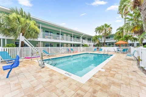 Dive into our sparkling saltwater pool with a spacious sun deck, lounge chairs, and handicap access — all surrounded by swaying palms, steps from the beach.