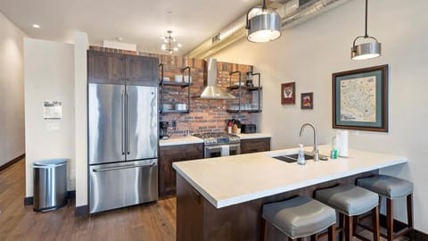 Fully stocked modern kitchen with seating for 3 at breakfast bar