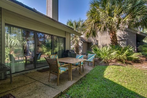 Sliding glass doors provide easy access from inside, creating an inviting spot for outdoor dining, morning coffee, or relaxed evenings in a quiet, natural setting.