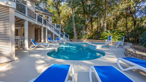 Large and spacious pool deck with seating, pool, and hot tub