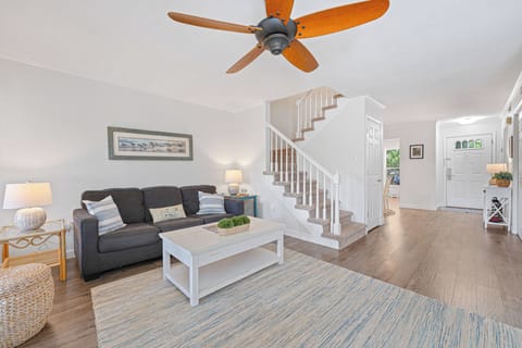 A comfortable sofa anchors the room, complemented by accent seating, a clean-lined coffee table, and soft neutral tones throughout.