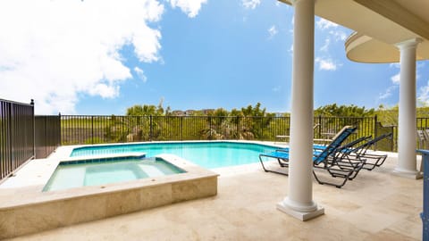 The sparkling pool features a refreshing spillover design and is framed by tropical palms and secure fencing for added peace of mind. (Heat optional)