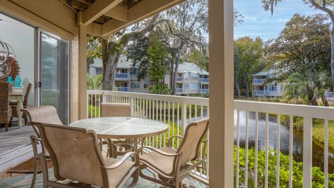 This covered balcony extends your living space outdoors, offering a comfortable spot for dining, morning coffee, or relaxing after a day at the beach.