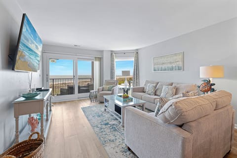 Step into this inviting oceanfront living room featuring comfortable seating, sliding doors to your private balcony, and sweeping views of the Atlantic.