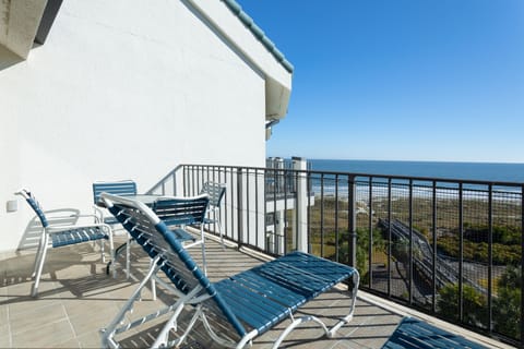 This private balcony offers a peaceful outdoor retreat with treetop and beach views.