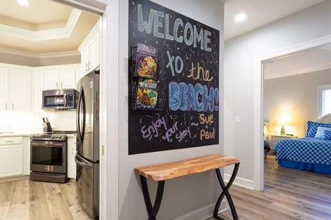 A welcoming entry sets the tone as you step inside, featuring a wood floor foyer with soft coastal colors and classic finishes.