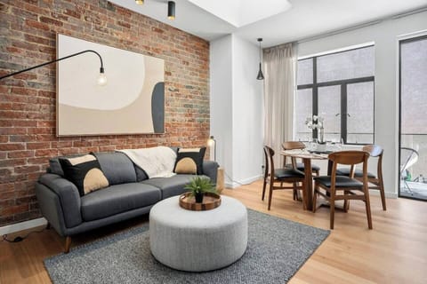 Bask in the warmth and sophistication of this light-filled living area. Polished floorboards and exposed brick walls create a cosy atmosphere, while plush furnishings and contemporary artwork invite you to relax.