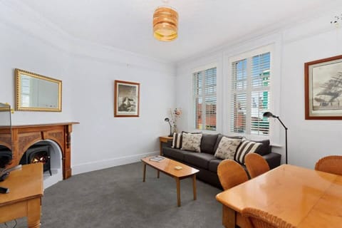 Relax in the spacious living room with a family-sized sofa, a large TV, and a charming fireplace, which is shared with the dining area.