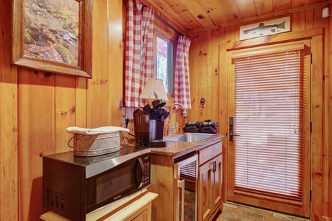 Downstairs kitchenette with keurig microwave sink and entrance to outdoor firepit