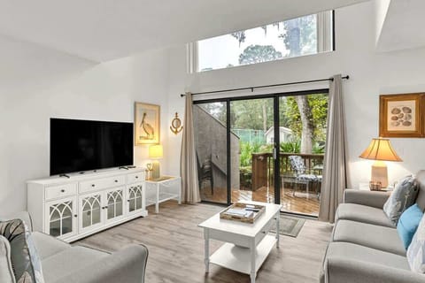 Modern living room with large sliding glass doors opening to a private deck.