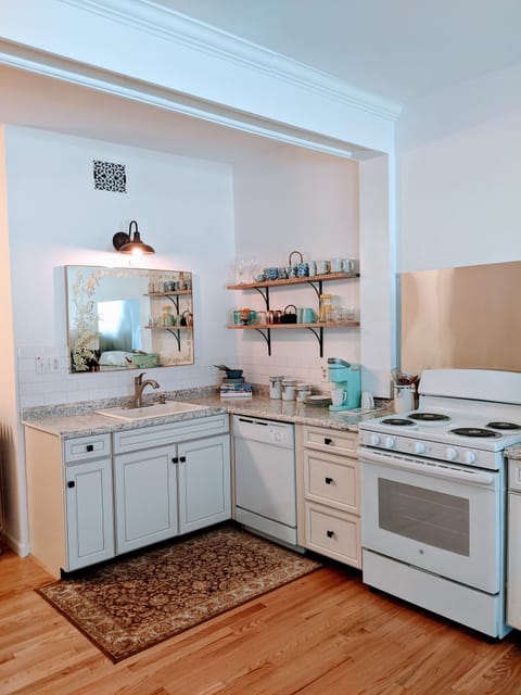 Original wood beam spans across the studio apartment with full kitchen