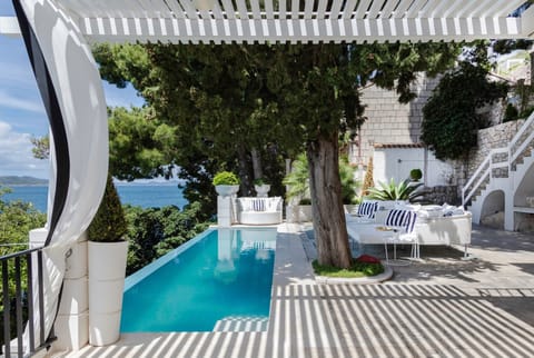 Lounge chairs by the infinity pool on the terrace of the Croatia beachfront villa Sea Diamant