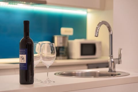 Wine served on the kitchen island and kitchen with microwave and coffee machine in a luxurious stone villa in the center of Bol
