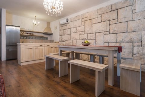 Fully-equipped kitchen and dining area in beachfront luxury villa on Brač with pool for vacation and rent.