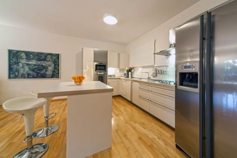 Bar with bar stools and the interior of the spacious fully equipped kitchen on the ground floor of the family villa with pool Primosten Oasis