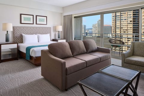 Your stylish retreat features a plush king bed, cozy sofa, and private balcony overlooking the vibrant cityscape—perfect for unwinding after a day of adventure.