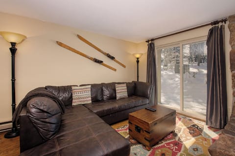 Cozy living room with vintage skis and snowy mountain views awaits your alpine getaway relaxation.