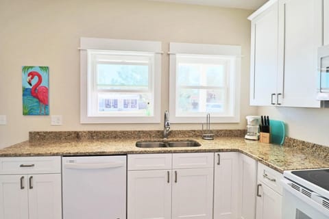 Beautiful granite counter tops a dishwasher, coffee maker and electric stove round out this view of the kitchen.  Lots of windows in this home allow for tons of natural light.