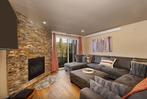 Sink into plush sectional seating while the stone fireplace creates a cozy glow in your stylish living space.