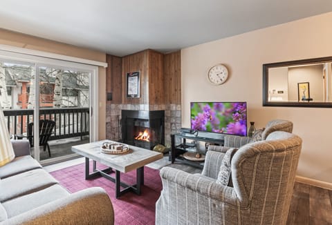 Premier Snow Flower Condominium 107's living room with fireplace and flat screen TV.