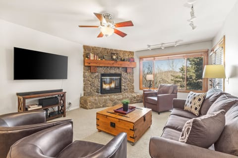 Snow Flower Condominium 14's living room with cozy fireplace and views of Park City Mountain.