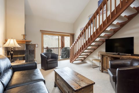 Living room features flat screen TV and leather furniture