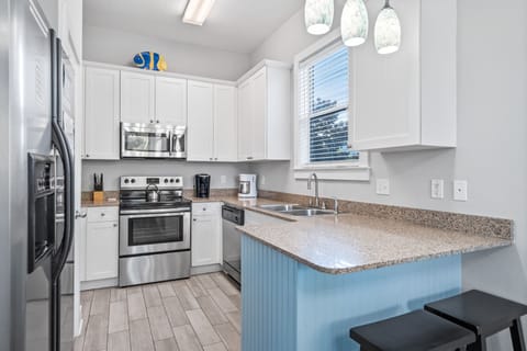 Fully Stocked Kitchen with Stainless Steel Appliances and Bar Seating for 2