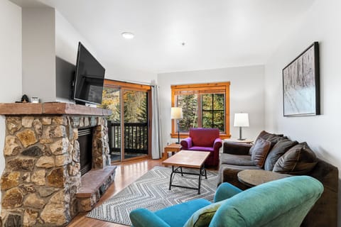 Cozy up by your stone fireplace while enjoying forest views through large windows. The perfect space to unwind after your mountain adventures.