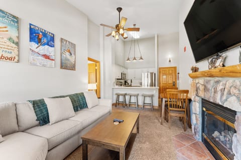 Settle into your cozy mountain retreat with a crackling fireplace, modern kitchen, and vintage ski posters setting the perfect alpine mood.