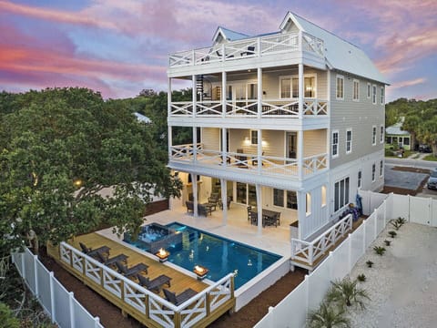 Striking multi-level coastal home w/ expansive balconies & a resort-style pool below.